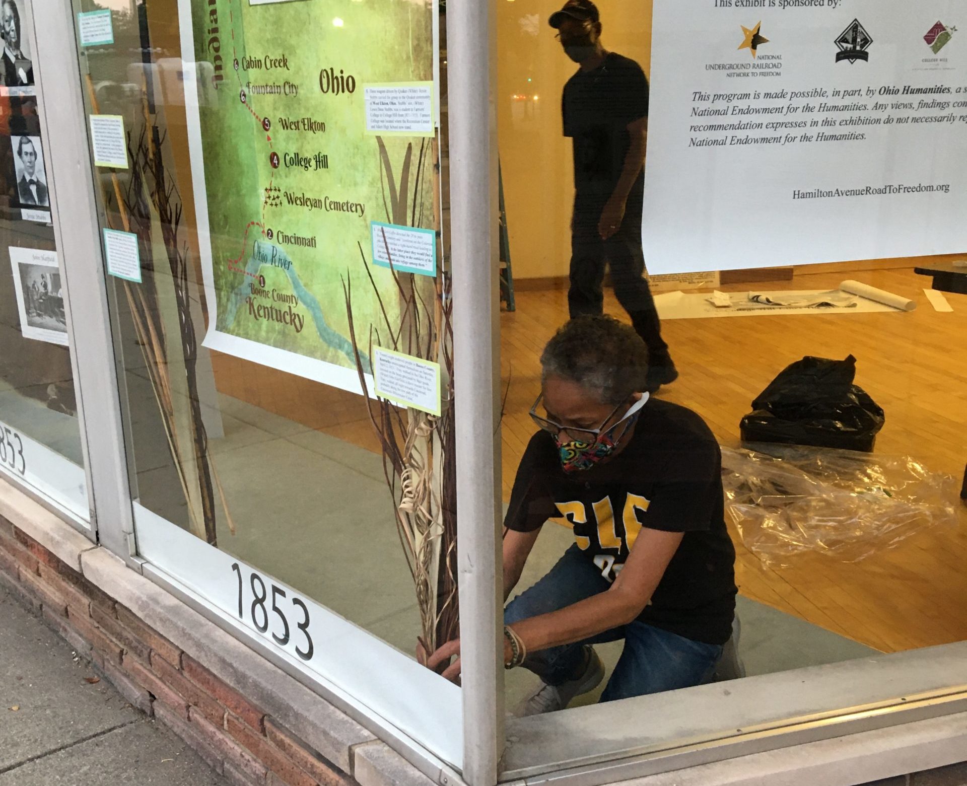 A worker installs a window exhibit at the College Hill Historical Society in Cincinnati