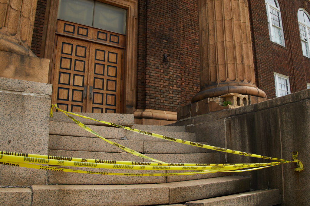 Caution tape prevents pedestrians from walking up Cory's crumbling stairs to the building's main doors