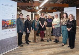 The team that curated the Illuminate exhibit, including two 2025 summer research fellows, poses for a photo next to the opening panel at the Legacy Fund of The Columbus Foundation's 25th anniversary event at Stonewall Columbus in November 2025.